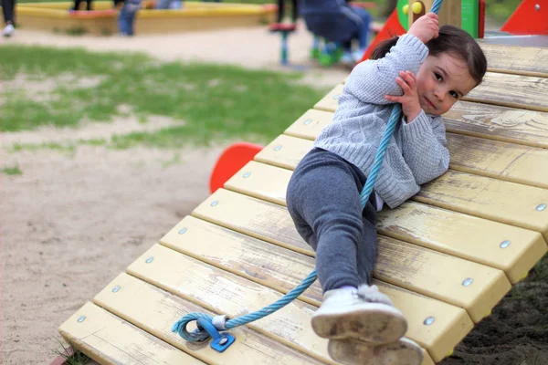 Ένα παιδί σκαρφαλώνει σε τεντωμένο σχοινί στην παιδική χαρά — Φωτογραφία Αρχείου