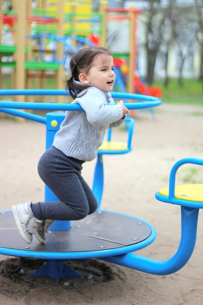 Cavalcate bambino sulla giostra nel parco giochi — Foto Stock