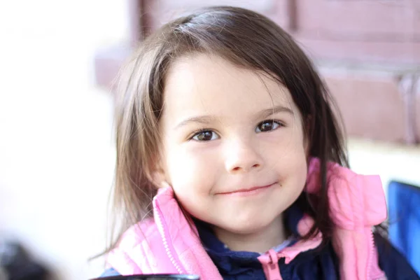 Küçük kız masada açık havada oturan gülümseyen — Stok fotoğraf