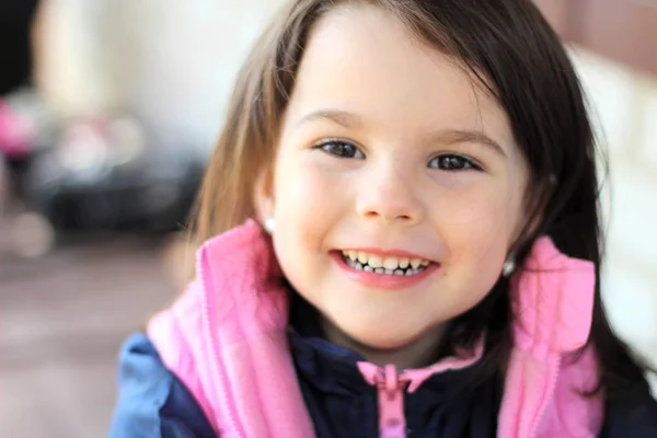 Niña sonriendo sentada en la mesa al aire libre —  Fotos de Stock