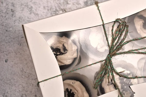 콘크리트 배경에 밧줄로 묶인 흰색 상자에 컵 케이크를 덮은 아름다운 초콜릿 크림 — 스톡 사진