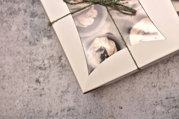 Güzel çikolatalı kek beton bir arka plan üzerinde bir ip ile bağlı beyaz bir kutu içinde krema ile kaplı — Stok fotoğraf