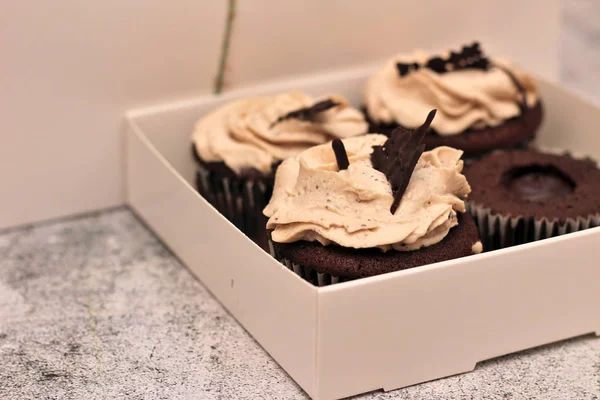 Красивые шоколадные кексы в белой коробке с веревкой на бетонном фоне — стоковое фото