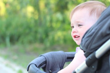 kolsuz gömlekli bebek arabasında küçük, güzel, gülümseyen, sevimli kızıl saçlı bebek