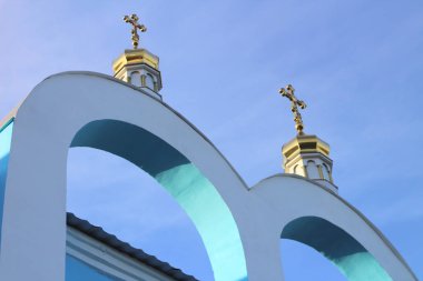 mavi gökyüzüne karşı Ortodoks kilisesinin mavi-beyaz kemerler üzerinde haçlar ile altın kubbeler