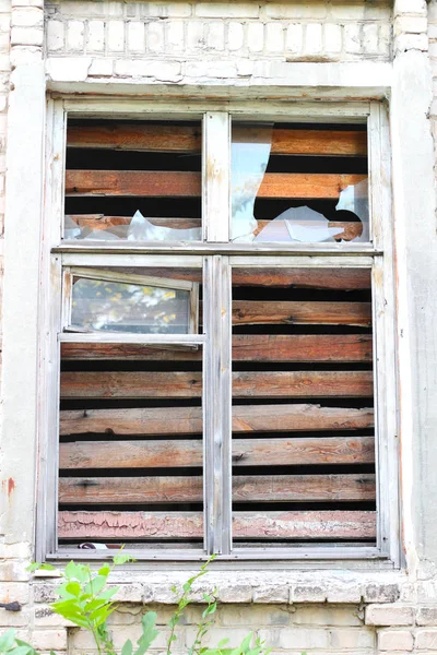 smashed a shot of an old brick building planked window at the Donbass in Ukraine