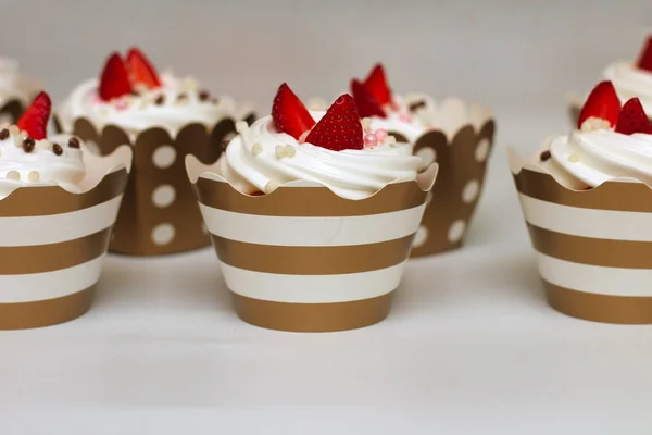 Gros plan cupcakes aux œufs fouettés crème décorée de fraises fraîches et de boules de chocolat sur fond blanc. Isoler — Photo