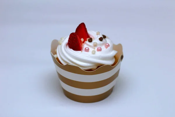 Gros plan cupcake aux œufs fouettés crème décorée de fraises fraîches et de boules de chocolat sur fond blanc. Isoler — Photo