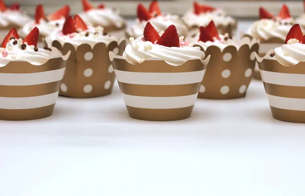 特写纸杯蛋糕与奶油奶油装饰新鲜的草莓和巧克力球在白色背景。分离 — 图库照片