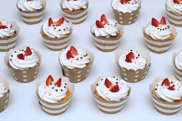 ホイップエッグクリームのクローズアップカップケーキは、白い背景に新鮮なイチゴとチョコレートボールを飾りました。分離されたトップ ビュー — ストック写真