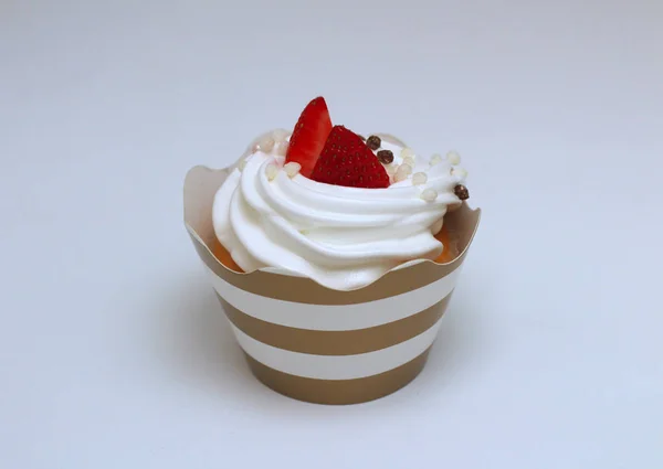 Cupcake close-up com chantilly ovos creme decorado bolas de morango e chocolate frescos no fundo branco. Isolar — Fotografia de Stock