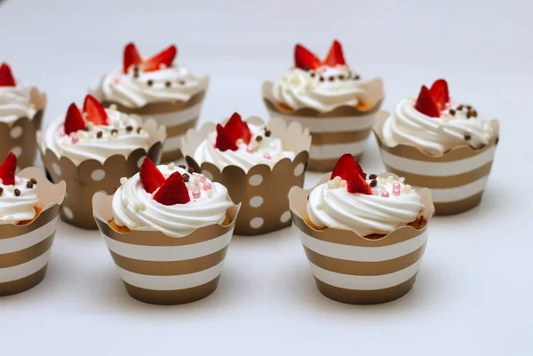 ホイップエッグクリームのクローズアップカップケーキは、白い背景に新鮮なイチゴとチョコレートボールを飾りました。分離 — ストック写真
