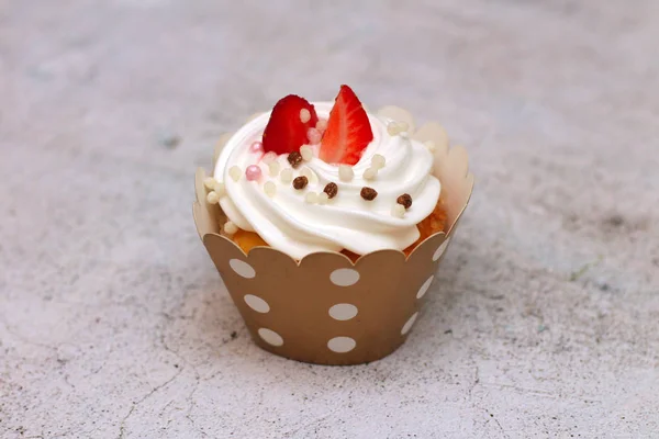 Close-up Cupcakes met opgeklopte eieren crème ingericht verse aardbei en chocolade ballen op oude betonnen tafel achtergrond. — Stockfoto