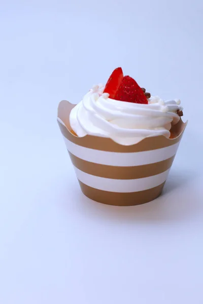 Cupcake close-up com chantilly ovos creme decorado bolas de morango e chocolate frescos no fundo branco. Isolar — Fotografia de Stock