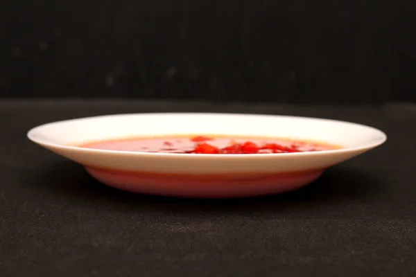 Cuenco de sopa de remolacha borscht con crema agria y verduras aisladas sobre lienzo negro con fondo oscuro — Foto de Stock