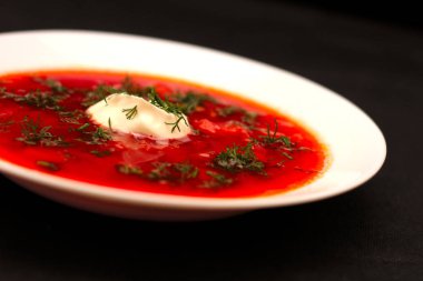 Ekşi krema ve koyu arka plan ile siyah tuval izole yeşillik ile pancar kökü çorba borscht Kase