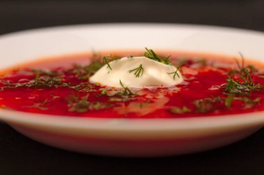 Ekşi krema ve koyu arka plan ile siyah tuval izole yeşillik ile pancar kökü çorba borscht Kase