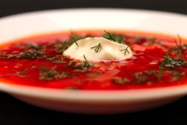 Ekşi krema ve koyu arka plan ile siyah tuval izole yeşillik ile pancar kökü çorba borscht Kase