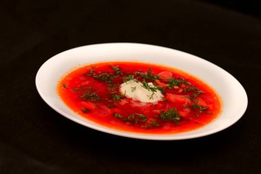 Ekşi krema ve koyu arka plan ile siyah tuval izole yeşillik ile pancar kökü çorba borscht Kase