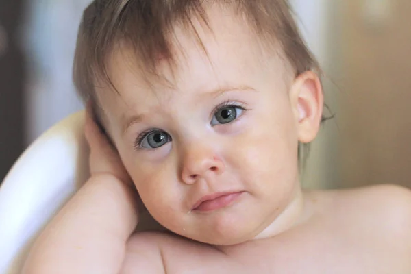 Nahaufnahme Porträt eines niedlichen lächelnden kleinen weißen Babys, das in einem Stuhl ohne Kleidung sitzt — Stockfoto