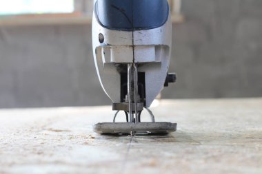 osb plaka üzerinde mavi-gümüş elektrikli yapboz. Osb kontrplak testere süreci