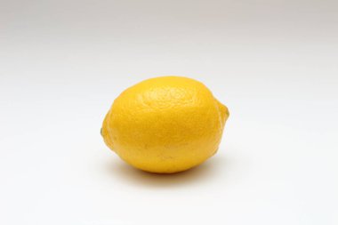 Beyaz bir arka plan üzerinde taze, olgun, izole, sulu tek limon. Stüdyo makro çekimi