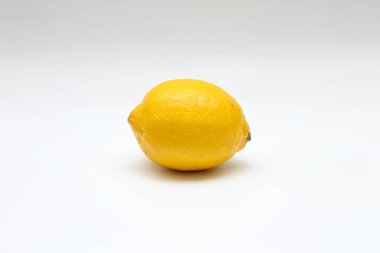 Beyaz bir arka plan üzerinde taze, olgun, izole, sulu tek limon. Stüdyo makro çekimi