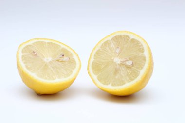 Taze, olgun, izole, sulu beyaz bir arka plan üzerinde limon ikiye bölünmüş. Stüdyo makro çekimi