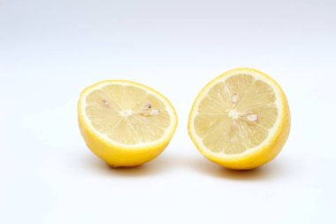 Taze, olgun, izole, sulu beyaz bir arka plan üzerinde limon ikiye bölünmüş. Stüdyo makro çekimi
