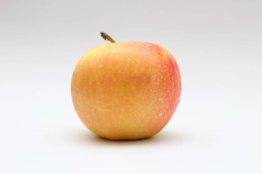 Beyaz arka planda izole tek sarı-turuncu-kırmızı elma. Stüdyo makro çekimi