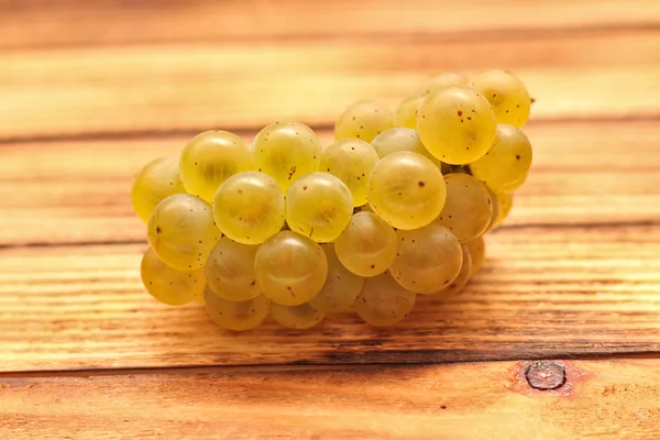 Isolated yellow bunches of grapes on wooden barrel boards — Stock Photo, Image
