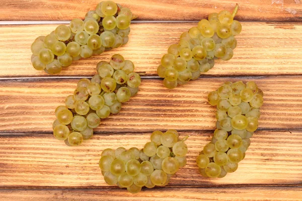 Isolated yellow bunches of grapes on wooden barrel boards — Stock Photo, Image