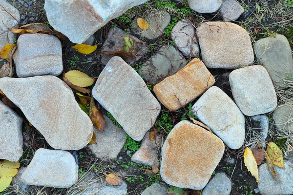 Pile of rounded stones on autumn grass — Stock Photo, Image