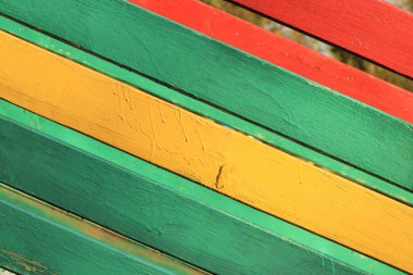 Çivili tahtaların yüzeyi yeşil, sarı ve kırmızıya boyanmış. Arkaplan resmi