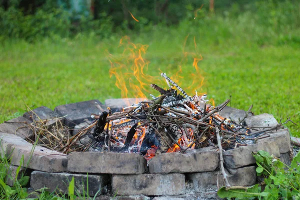 Κάψιμο Φωτιά Ένα Τζάκι Τούβλο Ένα Φόντο Πράσινο Γρασίδι Και — Φωτογραφία Αρχείου