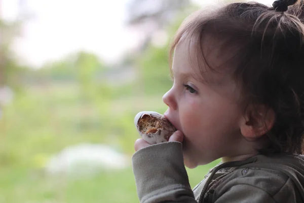 Little Beautiful Baby Profile Gnawing Bun Blurred Natural Background — Stock Photo, Image