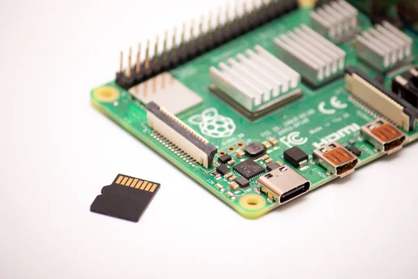 Kiev, Ukrayna - 13 Ağustos 2020: Ahududu Pi 4 prototip tahtası, beyaz arka planda alüminyum soğutmalı ısıtıcılar. Yüklenmiş Linux işletim sistemi bilgisayarın yanında duran kaldırılabilir ortam deposu