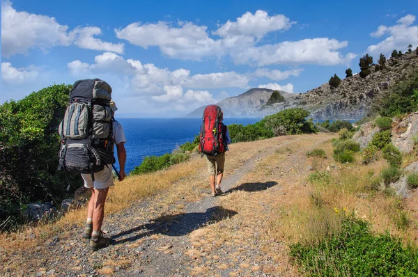 Turister med stora ryggsäckar gå längs vägen längs Medelhavet. Turkiet — Stockfoto