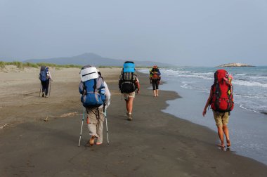 turistler ile büyük sırt çantaları yalınayak Patara kumlu plaj gidin. Türkiye