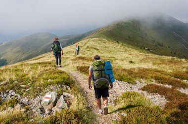 Büyük sırt çantaları turistlerle gruptur dağda