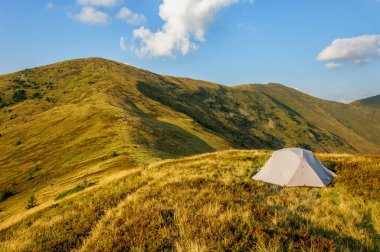 Karpatlar Ukrayna'da bir dağ zemin karşı çimenli yamaçta gri bir çadır