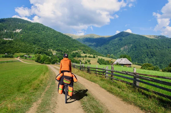 मोठ्या बॅकपॅकसह सायकलवर एक माणूस डोंगर रस्ता जॉर्जियावर चालतो — स्टॉक फोटो, इमेज