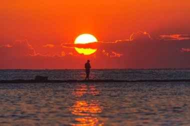 gün batımında genç adam siluet denizde