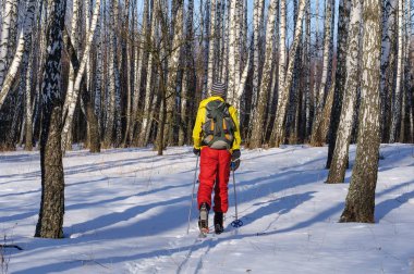 adam açık havada giysiler içinde donmuş nehir üzerinde ahşap kayaklar üzerinde biniyor