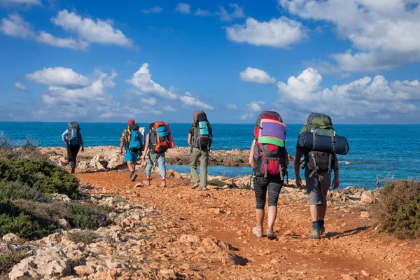 Büyük sırt çantaları turistlerle gruptur yol denizde — Stok fotoğraf