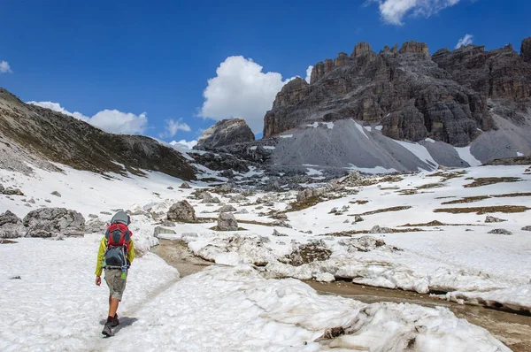 Otec s malým dítětem v batohu chodí po zasněžené Dolomitech, Itálie. — Stock fotografie