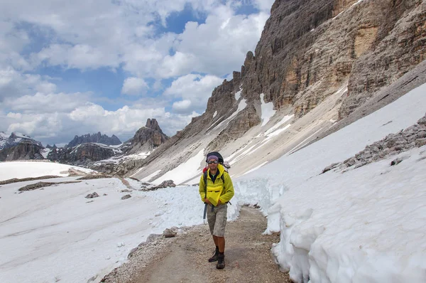 Papá con un niño pequeño en una mochila camina por dolomitas cubiertas de nieve, Italia . — Foto de Stock