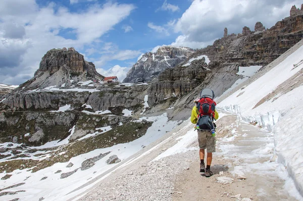 Papa avec un petit enfant dans un sac à dos marche le long de dolomites enneigées, Italie . — Photo