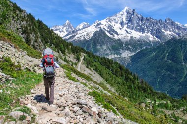 Bir sırt çantası küçük çocuk ile anne karla kaplı Dolomitler boyunca yürür, Italya.