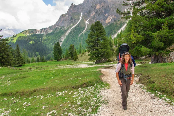 Mum with small child in a backpack walks along dolomites, Italy. — Stock Photo, Image